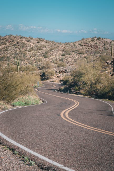 Explore a winding road cutting through the scenic desert landscape near Phoenix, AZ.