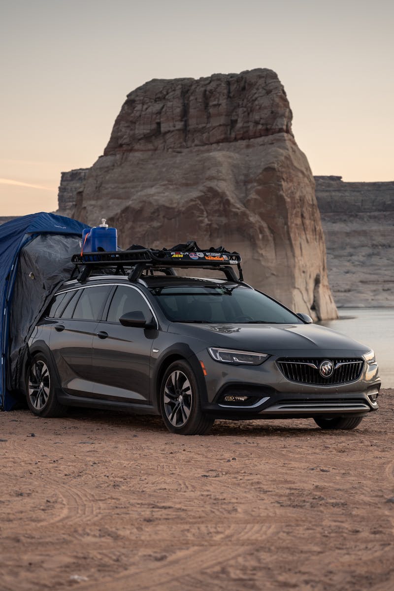 A car parked beside a tent at Lake Powell, perfect for a desert camping experience.