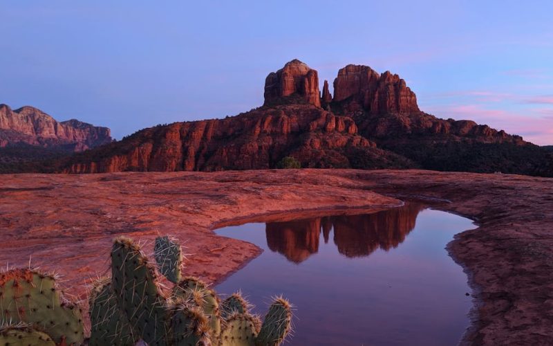 Stunning view of Cathedral Rock in Sedona, Arizona, reflecting in a puddle during sunset.