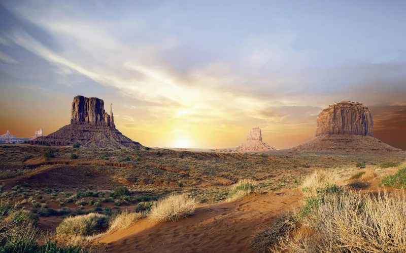 Breathtaking view of Monument Valley's iconic rock formations at sunset, showcasing vivid desert landscape.